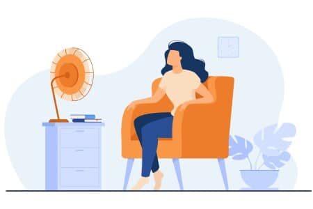 Concept d'une bulle de bien-être : femme assise dans son fauteuil profitant de la fraîcheur d'un ventilateur