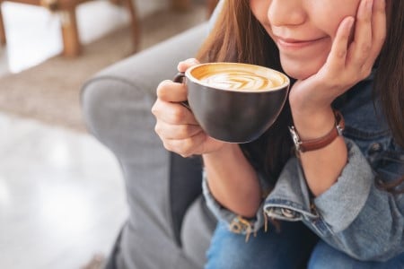 Gros plan sur une femme buvant une tasse de café chaud