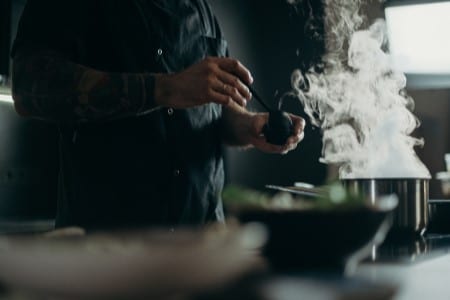 Homme en cuisine devant une casserole fumante