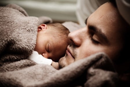 Homme endormi avec son bébé en gros plan