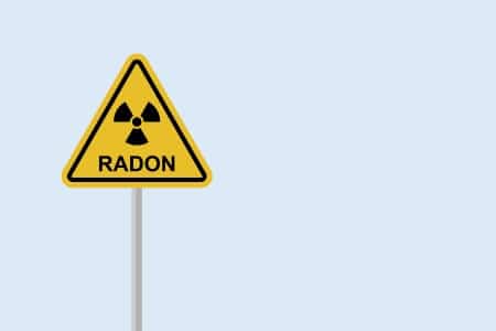 Risque au radon symbolisé par un panneau de danger sur fond bleu