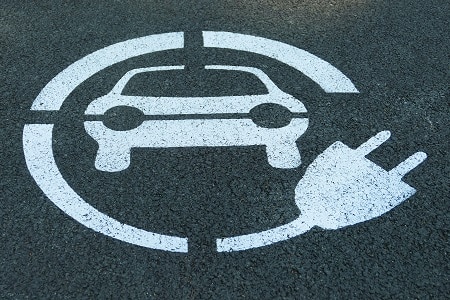 Symbole d'une voiture électrique sur le sol d'une place de stationnement